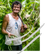 man in the bean crop holding vanilla beans